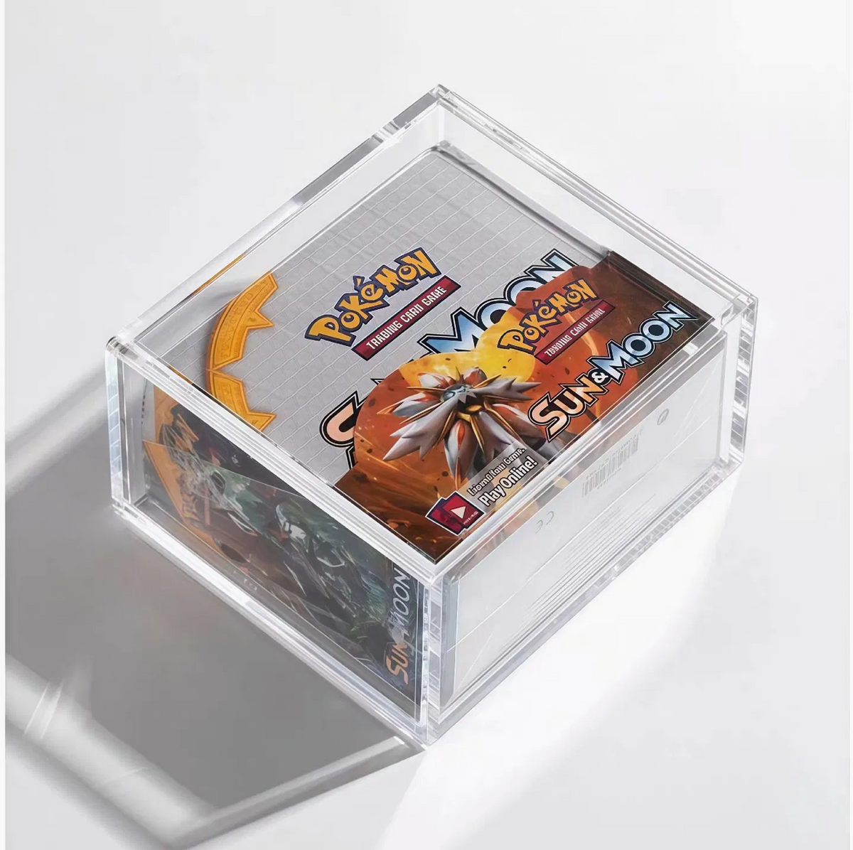 Angled acrylic display case with an English Pokémon Sun & Moon booster box shown for reference.